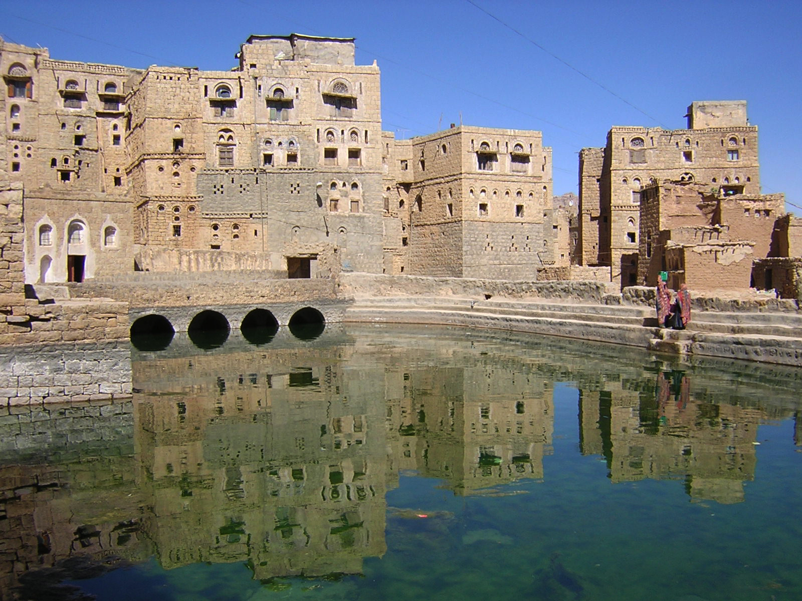 Hababa (Yemen) La città circonda la larga cisterna dove sono raccolte le acque provenienti dalle terrazze degli edifici. Il piccolo edificio a bordo dell'acqua è una moschea con vasche interne alimentate con acqua dalle arcate sottostanti