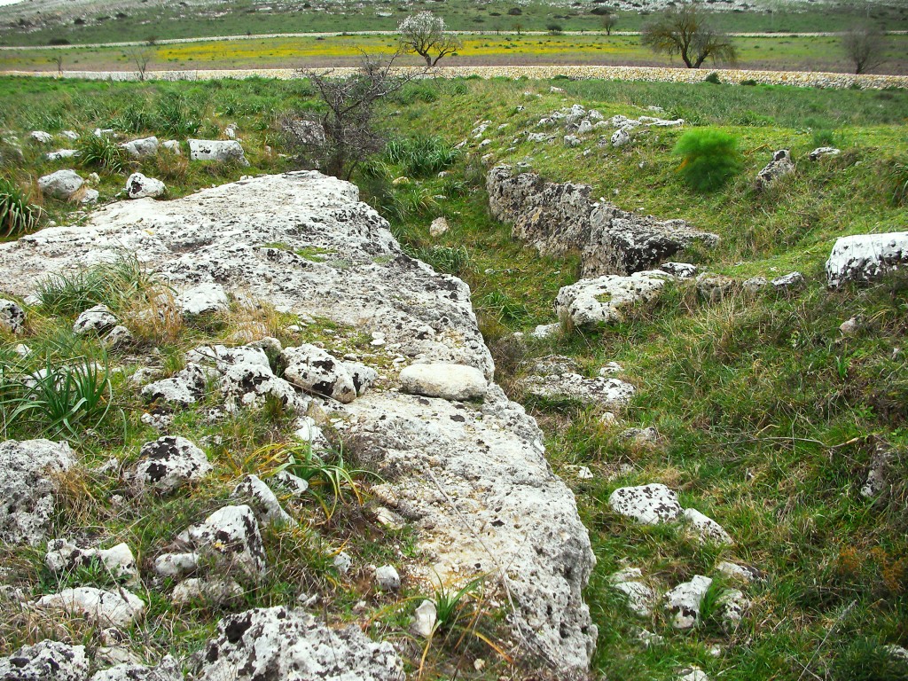 Murgia Timone - Due ellissi segnano il perimetro visibile del grande insediamento Neolitico, Solo un duro lavoro e la cooperazione collettiva, usando solo strumenti di pietra, ha reso possibile lo scavo