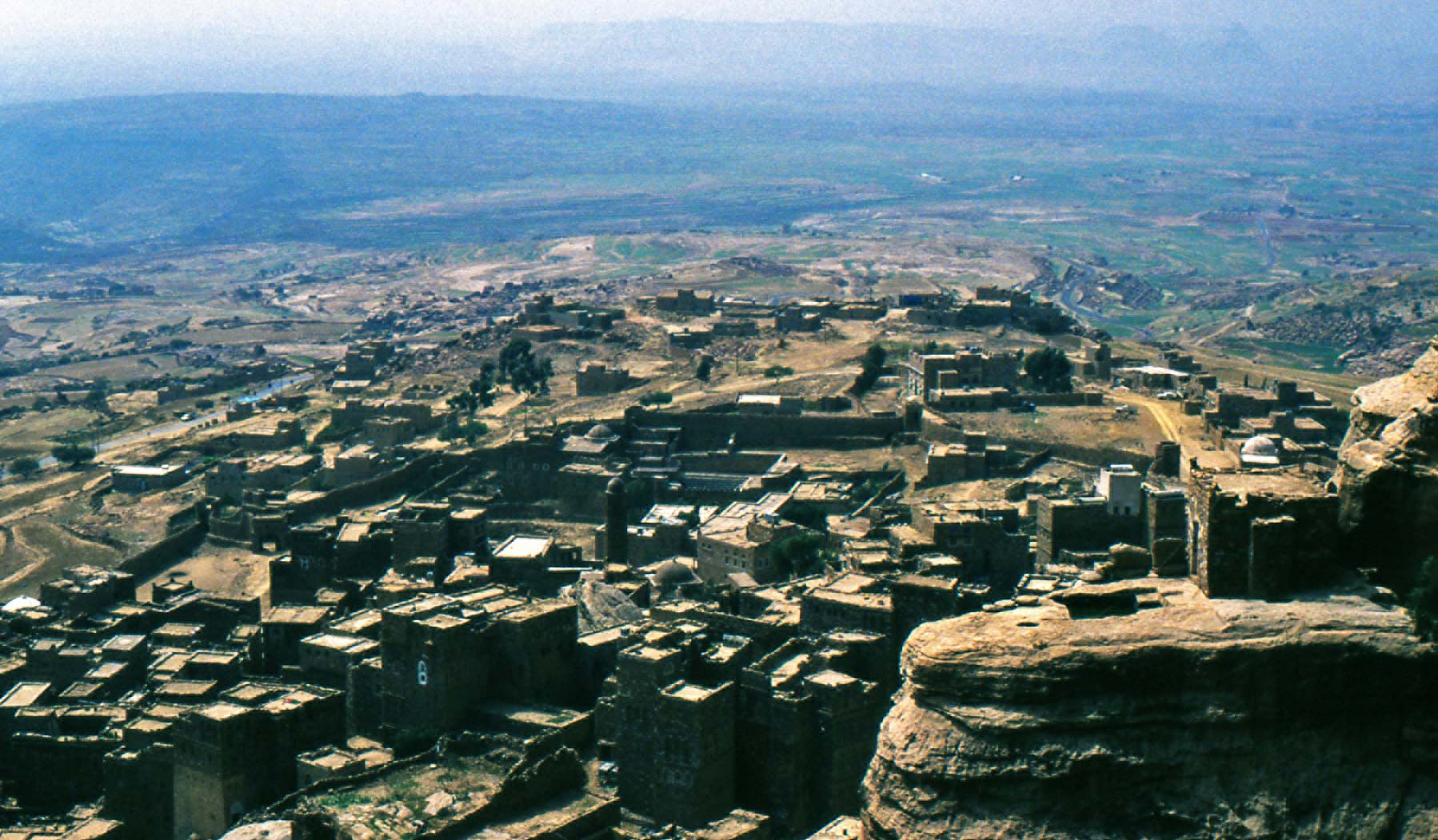 La vista della città bassa dalla rupe di Thula. Si nota una parte di mura che circondano l'abitato e sullo sperone in primo piano, una cisterna a cielo aperto scavata nella roccia