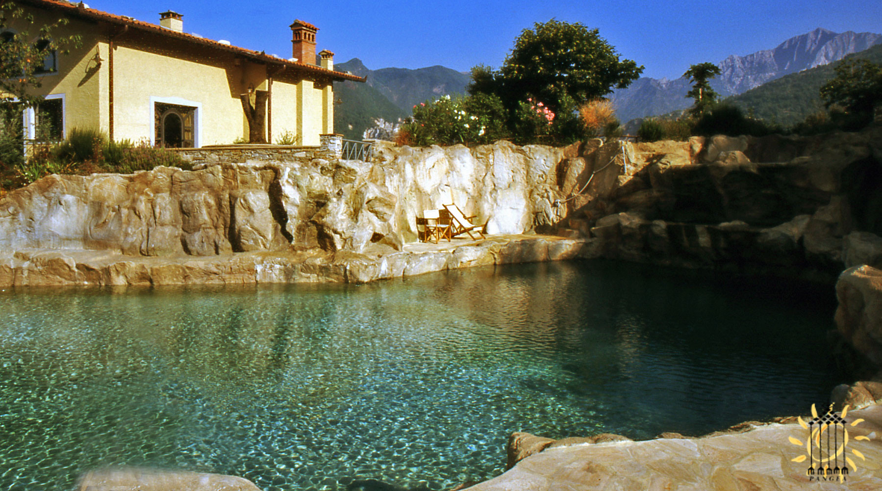 Una piscina in Toscana costruita con la pietra locale e riciclando l'acqua raccolta dalla copertura, tramite le grondaie